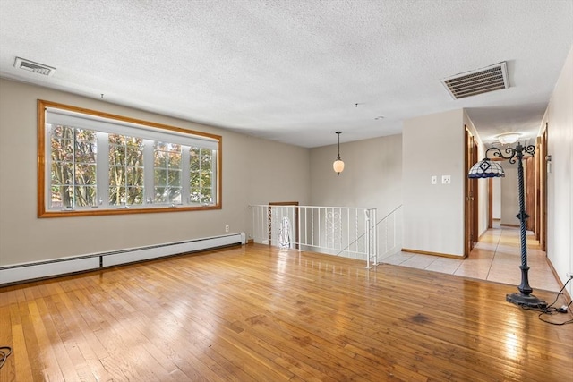 97 Marshall St, Revere, MA 02151 - empty room featuring a baseboard radiator, a textured ceiling, and wood-type flooring