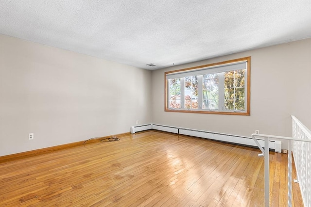 97 Marshall St, Revere, MA 02151 - empty room featuring a baseboard radiator, a textured ceiling, and wood-type flooring