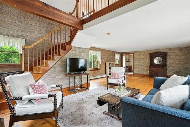 114 Center St, Carver, MA 02330 - living room with plenty of natural light, a high ceiling, stairway, a baseboard heating unit, and wood finished floors