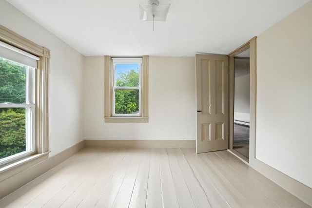 114 Center St, Carver, MA 02330 - spare room featuring healthy amount of natural light, light wood-style flooring, and a baseboard heating unit