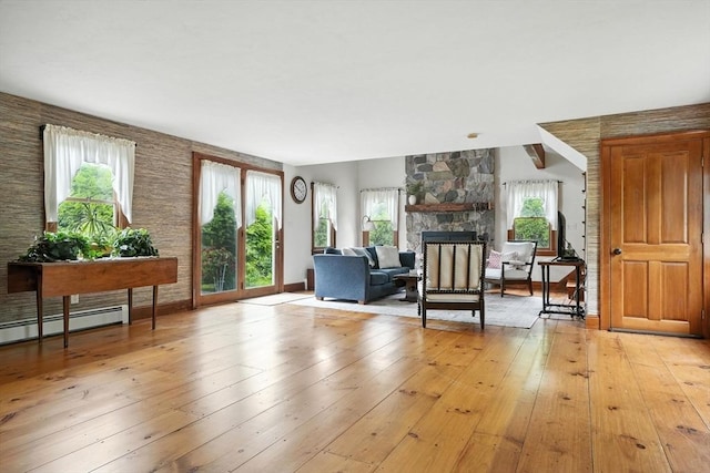 114 Center St, Carver, MA 02330 - living area with a fireplace, healthy amount of natural light, a baseboard heating unit, and light wood finished floors