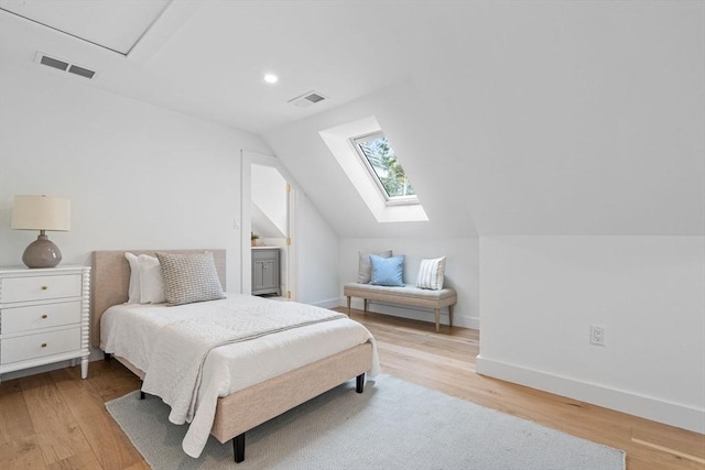 bedroom with visible vents, vaulted ceiling with skylight, baseboards, and light wood-style floors