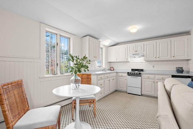 kitchen featuring under cabinet range hood, a wainscoted wall, light countertops, white range oven, and white cabinets