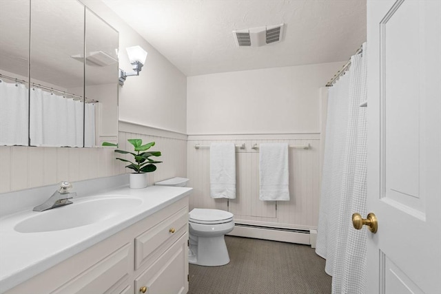 bathroom with visible vents, toilet, a baseboard heating unit, wainscoting, and vanity