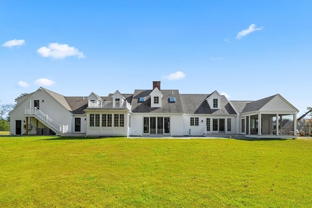 back of property with a yard, stairs, and a sunroom