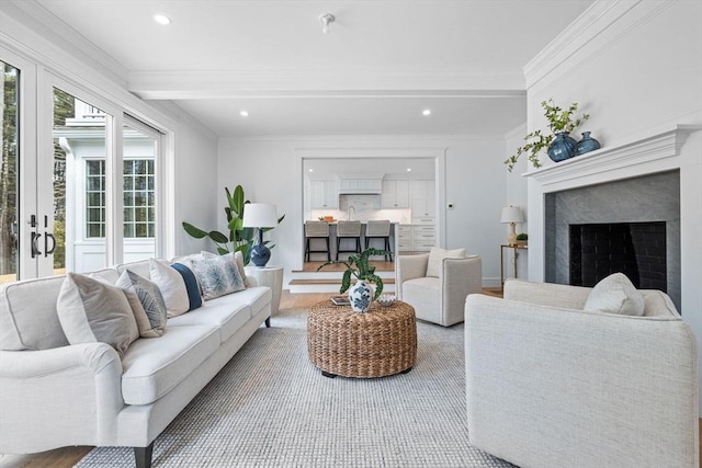 living area featuring beam ceiling, ornamental molding, recessed lighting, and a premium fireplace