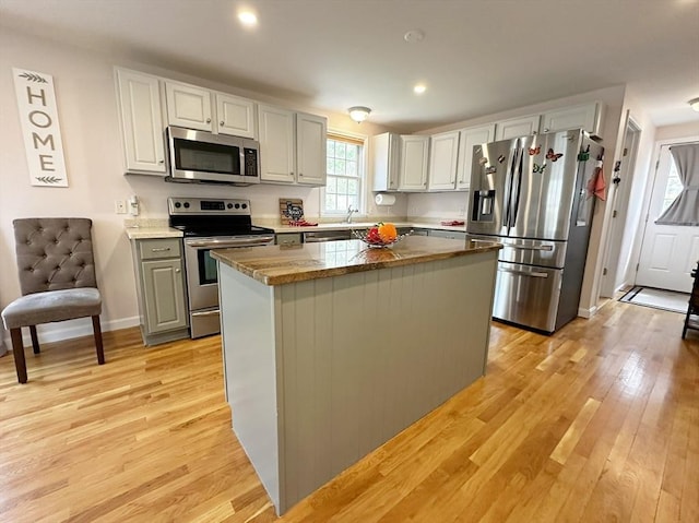121 Camp St Unit 108, Yarmouth, MA 02673 - kitchen featuring appliances with stainless steel finishes, a center island, a sink, light wood-style flooring, and recessed lighting