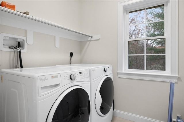 laundry area with separate washer and dryer and a wealth of natural light