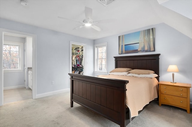 carpeted bedroom featuring ensuite bath, ceiling fan, a spacious closet, lofted ceiling, and a closet