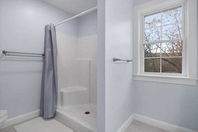 bathroom with curtained shower, tile patterned flooring, and toilet