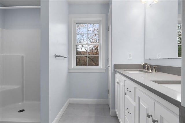 bathroom featuring tile patterned flooring, vanity, and walk in shower