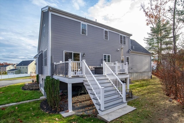 back of property with a yard and a wooden deck