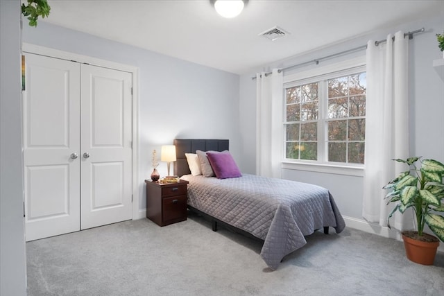 bedroom with light colored carpet and a closet