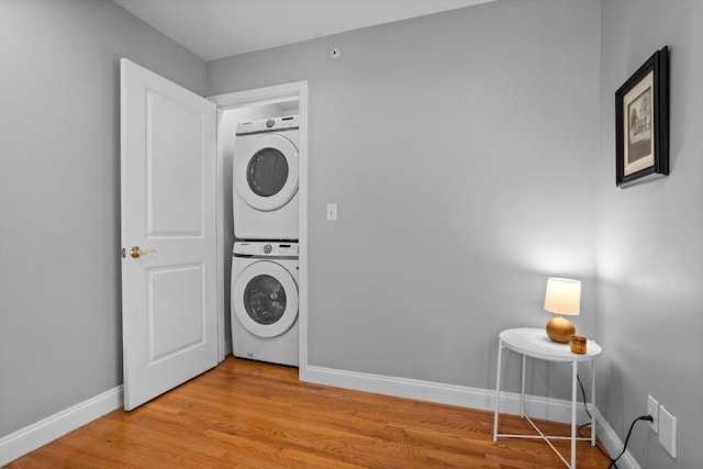 laundry room featuring light hardwood / wood-style flooring and stacked washer / dryer