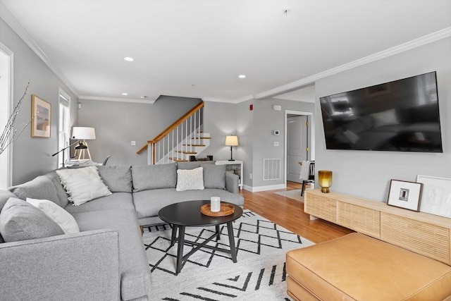 living room with light hardwood / wood-style floors and ornamental molding