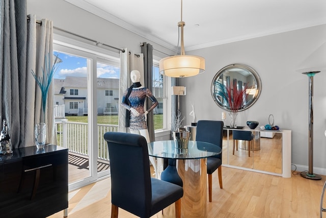 dining area with light wood-type flooring and crown molding