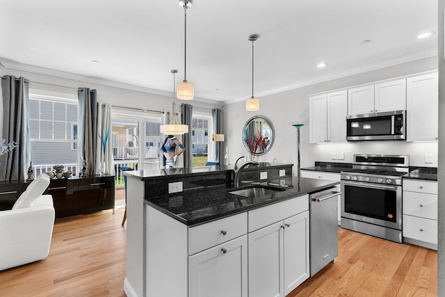 kitchen with pendant lighting, light wood-type flooring, stainless steel appliances, and white cabinetry