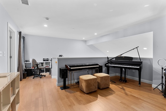 miscellaneous room with light wood-type flooring and vaulted ceiling