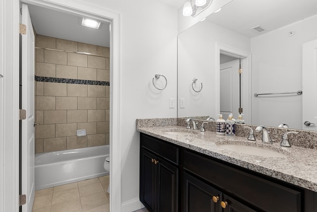 full bathroom featuring tile patterned flooring, vanity, toilet, and tiled shower / bath