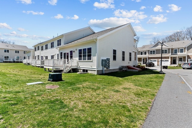 view of property exterior with a deck, a yard, and central air condition unit