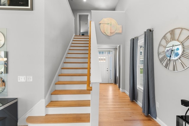 stairway with a towering ceiling and hardwood / wood-style flooring