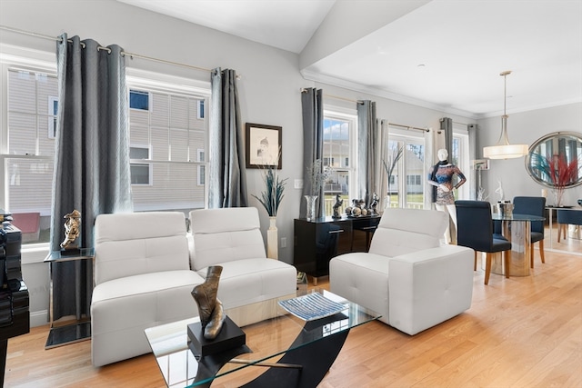 living room with lofted ceiling, crown molding, and light hardwood / wood-style flooring