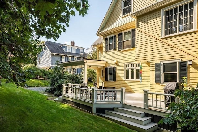 back of house with a deck and a yard