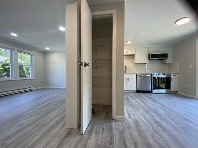 270 Sunderland Rd Unit 11, Worcester, MA 01604 - kitchen with appliances with stainless steel finishes, light wood-type flooring, white cabinets, baseboards, and recessed lighting