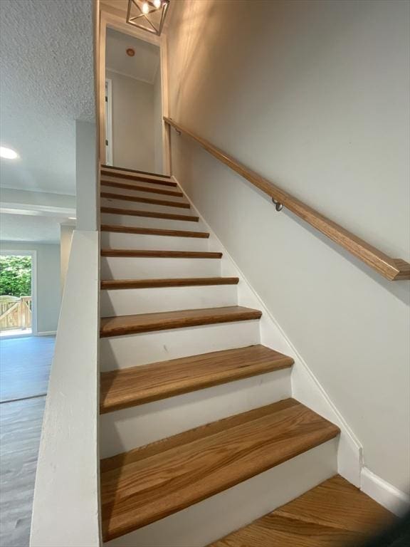 270 Sunderland Rd Unit 11, Worcester, MA 01604 - stairway with wood finished floors, a textured ceiling, and baseboards