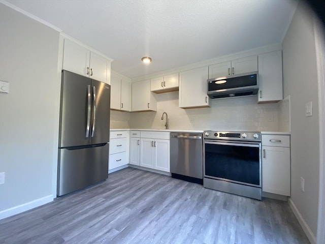 270 Sunderland Rd Unit 11, Worcester, MA 01604 - kitchen featuring appliances with stainless steel finishes, light wood finished floors, decorative backsplash, light countertops, and white cabinets