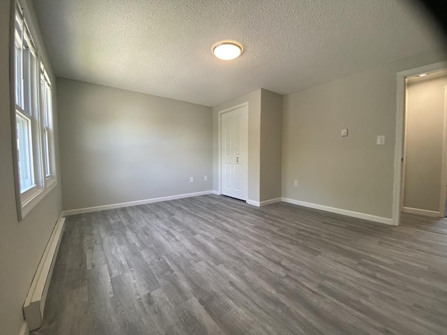 270 Sunderland Rd Unit 11, Worcester, MA 01604 - empty room with a baseboard radiator, a textured ceiling, dark wood finished floors, and baseboards