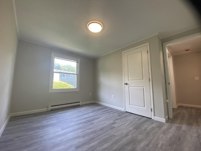 270 Sunderland Rd Unit 11, Worcester, MA 01604 - unfurnished bedroom featuring a baseboard heating unit, wood finished floors, ornamental molding, baseboards, and attic access