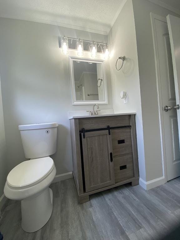 270 Sunderland Rd Unit 11, Worcester, MA 01604 - bathroom featuring baseboards, vanity, wood finished floors, toilet, and a textured ceiling