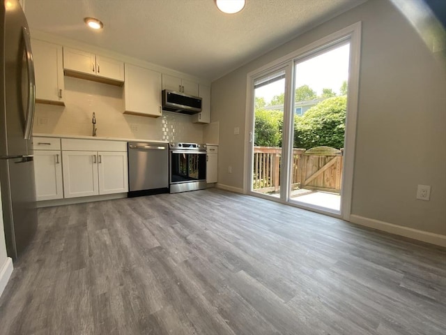 270 Sunderland Rd Unit 11, Worcester, MA 01604 - kitchen featuring appliances with stainless steel finishes, wood finished floors, baseboards, and a textured ceiling