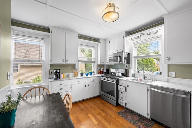 60 Lynnfield St, Lynn, MA 01904 - kitchen featuring stainless steel appliances, a sink, light wood finished floors, light countertops, and white cabinets