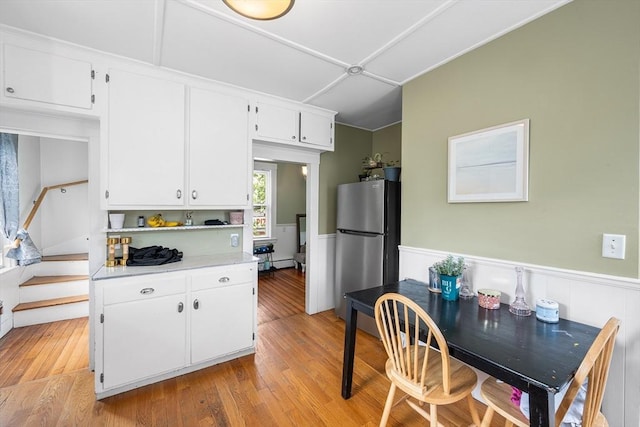 60 Lynnfield St, Lynn, MA 01904 - kitchen featuring freestanding refrigerator, white cabinets, wainscoting, light countertops, and light wood-type flooring