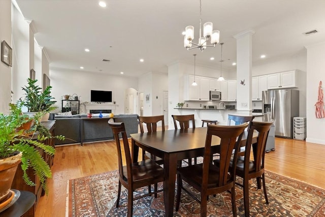 dining area with recessed lighting, visible vents, an inviting chandelier, and light wood-style floors