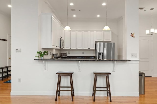 kitchen featuring a breakfast bar area, white cabinets, and stainless steel appliances