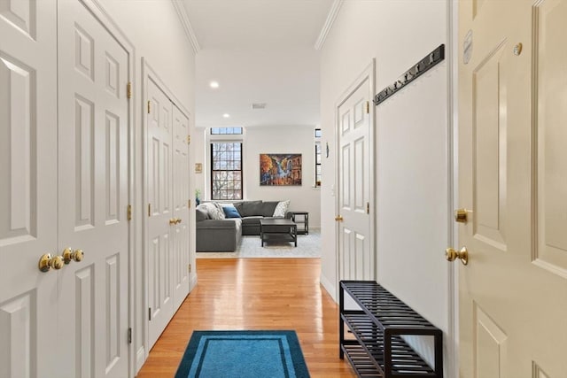 hallway featuring recessed lighting, ornamental molding, and light wood finished floors