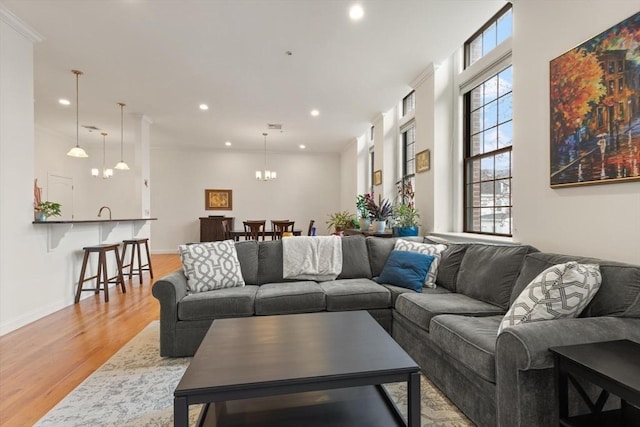 living room with recessed lighting, baseboards, a notable chandelier, and light wood-style floors