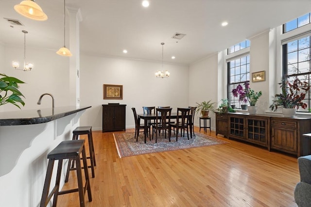 dining space with recessed lighting, an inviting chandelier, light wood finished floors, and visible vents