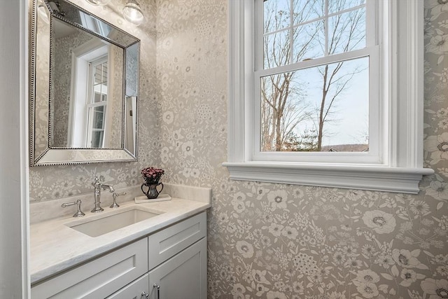 bathroom featuring vanity, a wealth of natural light, and wallpapered walls