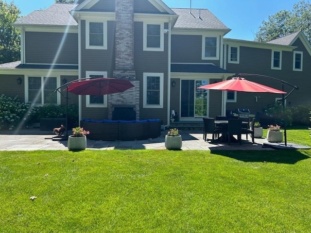 rear view of house with a yard and a patio