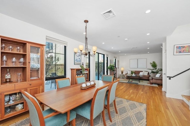 dining space with recessed lighting, a notable chandelier, visible vents, stairs, and light wood-type flooring