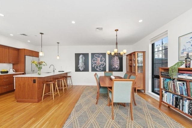 dining space featuring a chandelier, recessed lighting, visible vents, and light wood finished floors