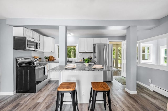 759 Millers Falls Rd, Northfield, MA 01360 - kitchen featuring appliances with stainless steel finishes, a breakfast bar area, white cabinets, a center island, and wood finished floors