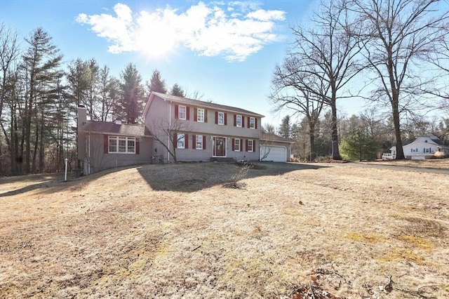 colonial home featuring a chimney and a garage