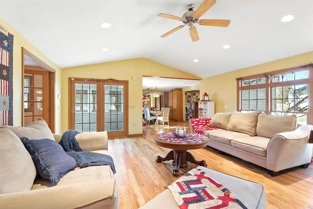 living room featuring light wood finished floors, plenty of natural light, french doors, and lofted ceiling