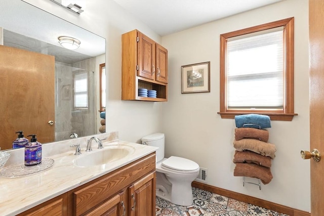 bathroom featuring a shower with shower door, visible vents, toilet, baseboards, and vanity