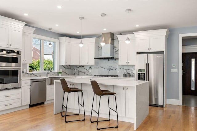 kitchen with a kitchen breakfast bar, light countertops, wall chimney exhaust hood, backsplash, and stainless steel appliances